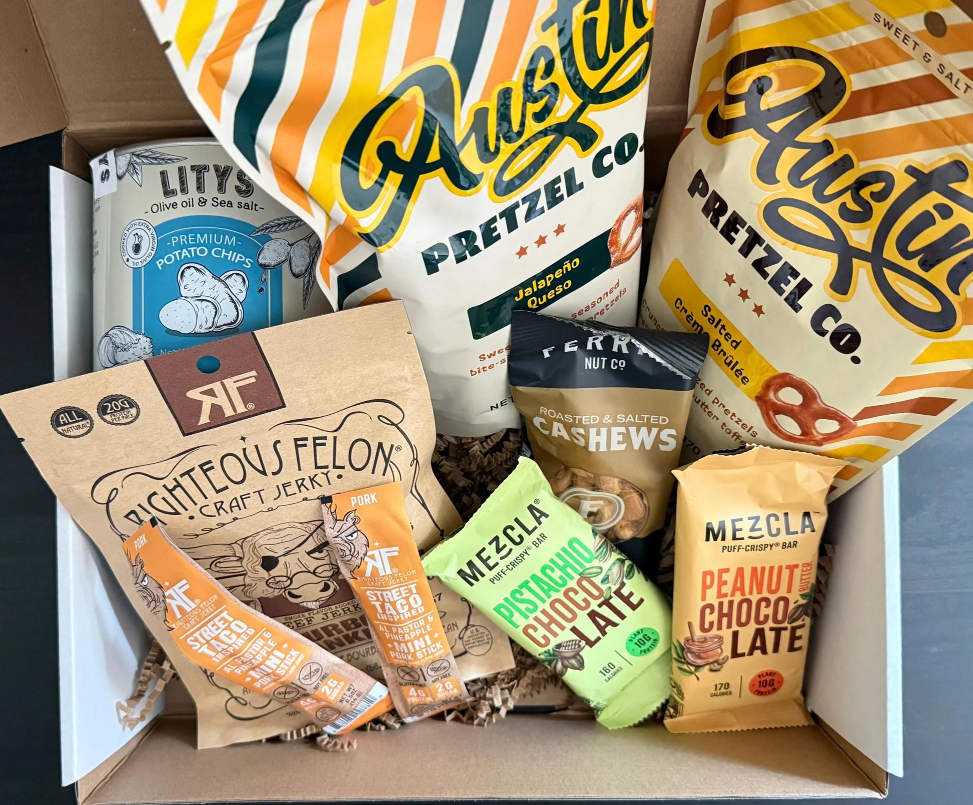 Gift box with pretzels, potato chips, craft jerky, nut bars, and roasted cashews