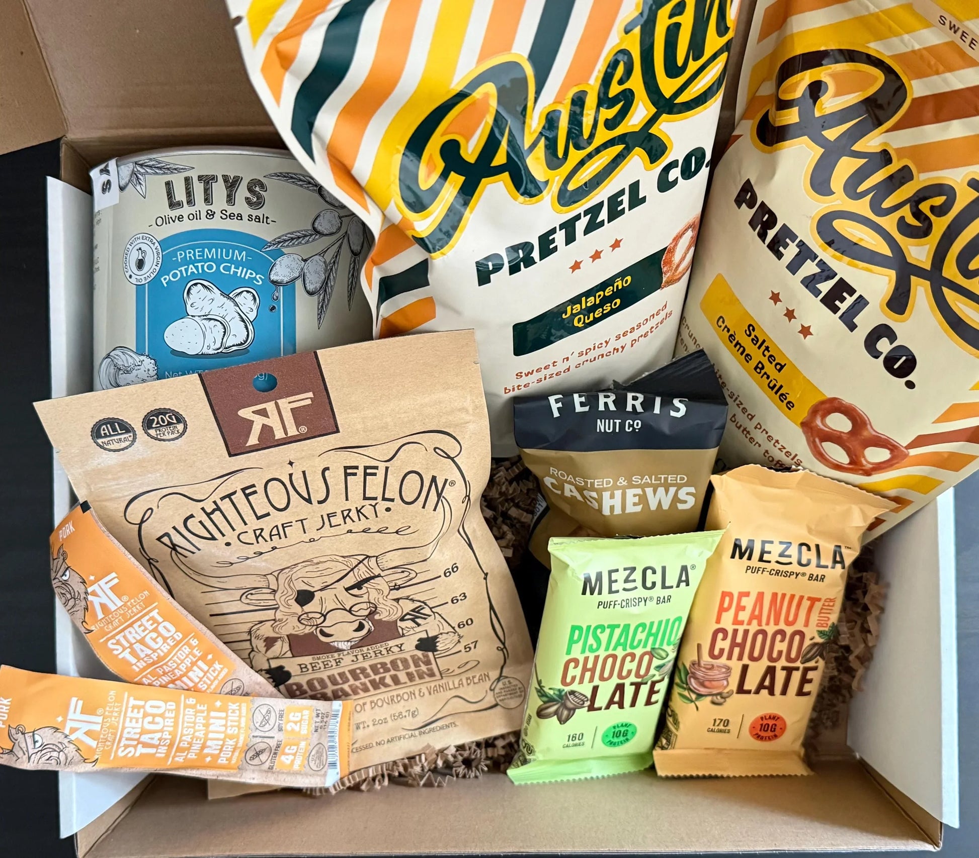 Artisan snack gift box with pretzel, potato chips, beef jerky, cashews, and chocolate bars