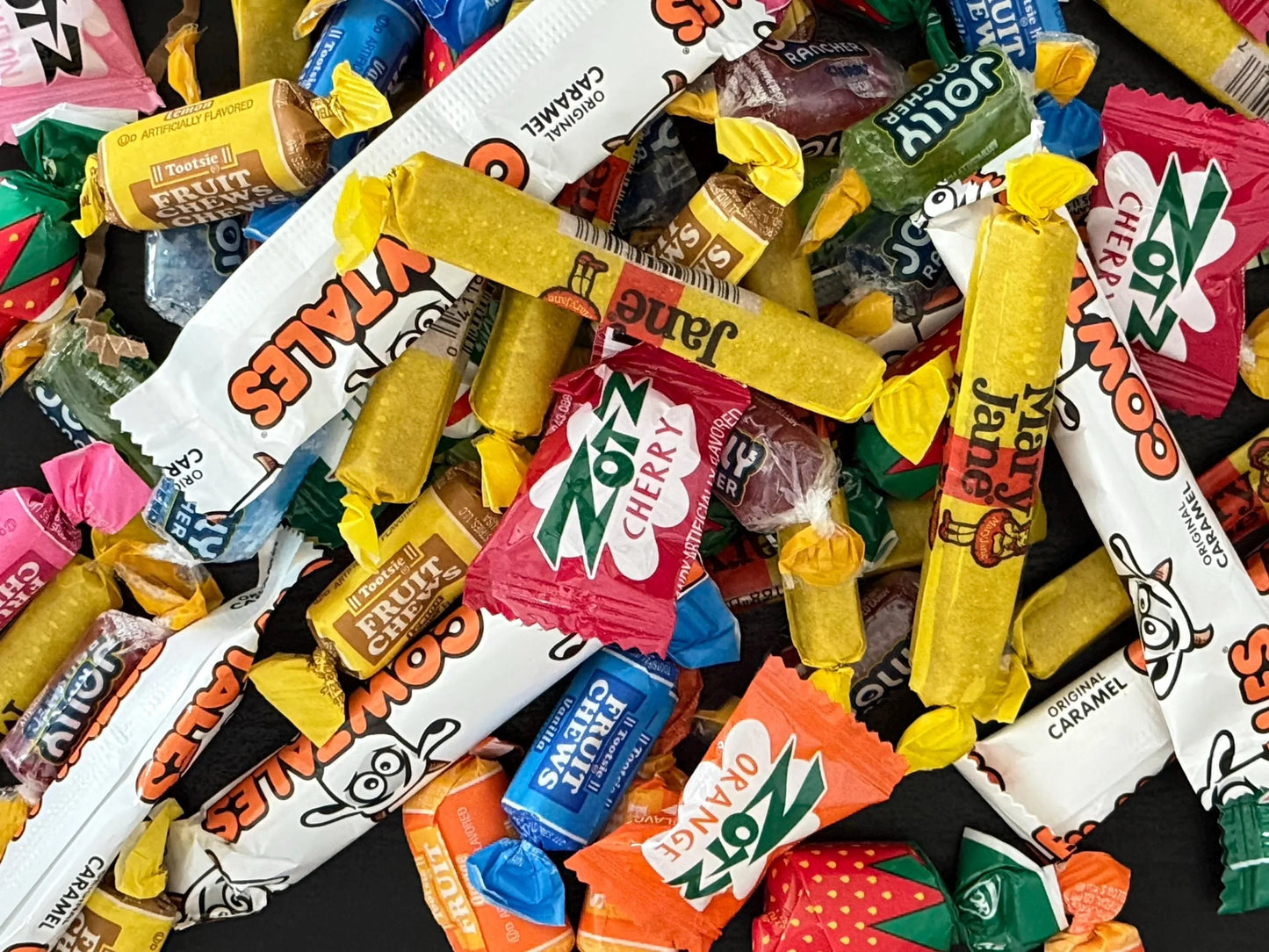 Assorted nostalgic candies including Cow Tales, Tootsie Fruit Chews, Zotz, and Mary Jane