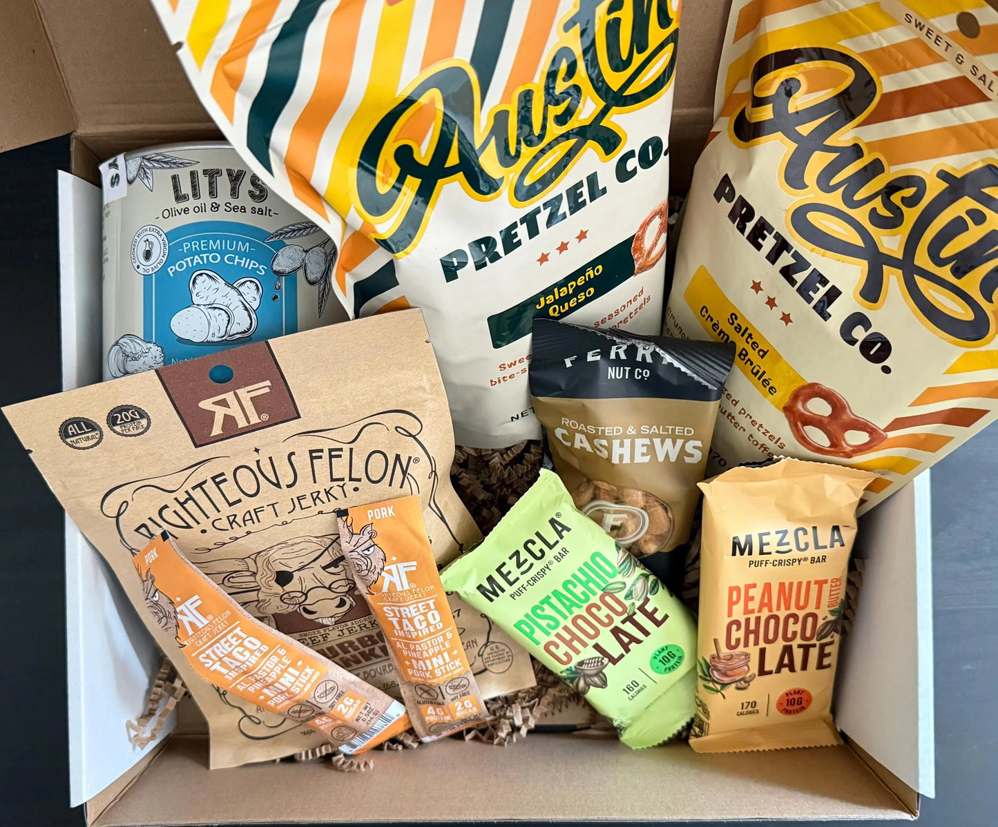 Gift box with pretzels, potato chips, cashews, jerky, and chocolate snack bars