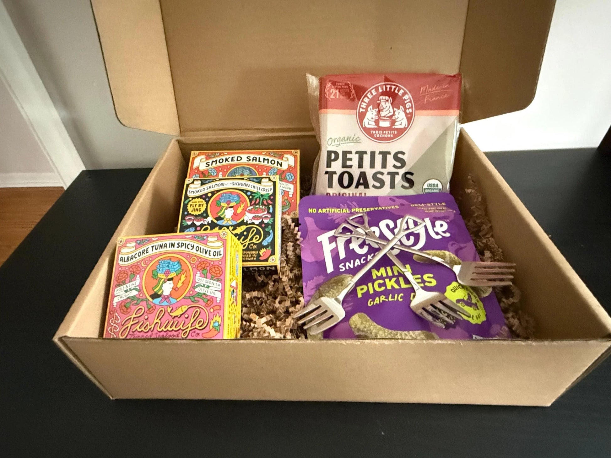 Gift box with smoked salmon, albacore tuna, mini pickles, petits toasts, and two forks