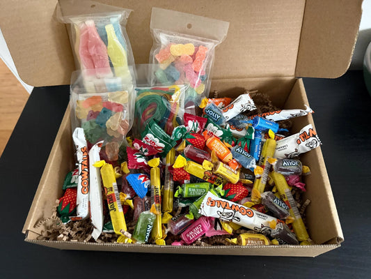 Assorted candy gift box with gummies, chewy sweets, and wrapped treats in a cardboard box