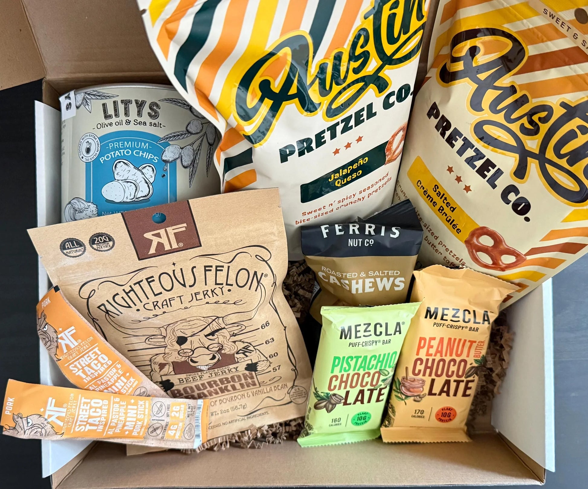 Gift box with gourmet pretzels, potato chips, craft jerky, cashews, and snack bars