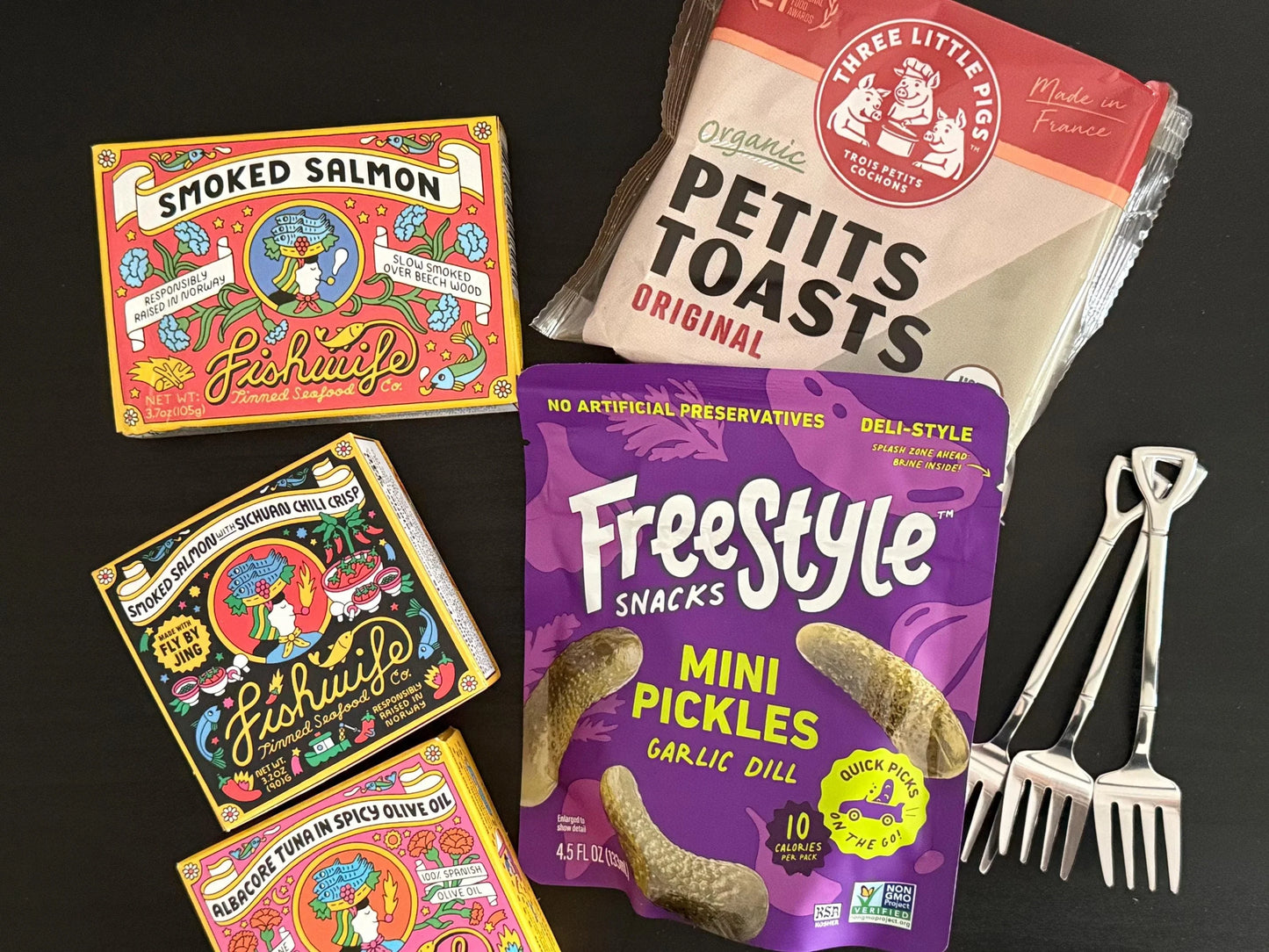 Gift box assortment with smoked salmon tins, mini pickles, Petits Toasts, and appetizer forks