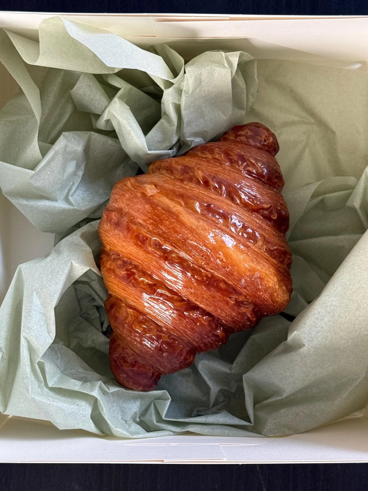 Buttery golden croissant in gift box with tissue paper, gourmet baked pastry