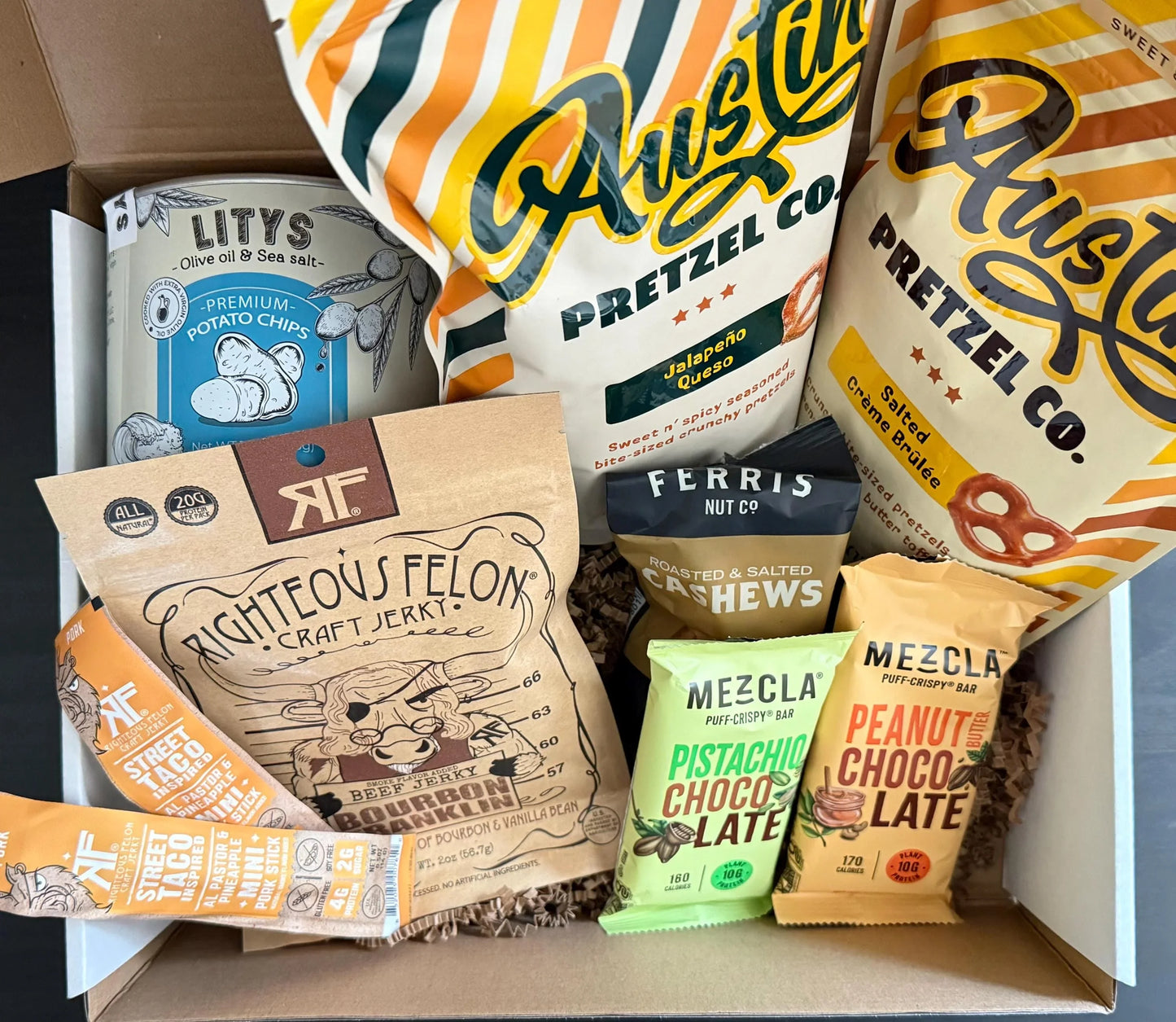 Gourmet snack gift box with pretzels, potato chips, jerky, cashews, and chocolate bars
