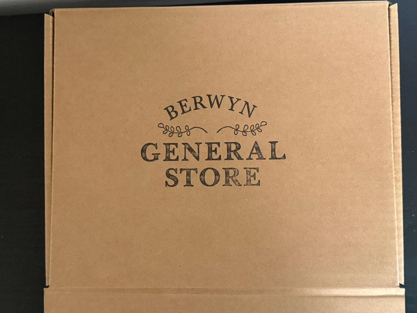 Brown cardboard shipping box with Berwyn General Store logo on lid